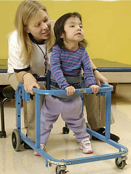 женщина помогает  девочке  учиться  ходить